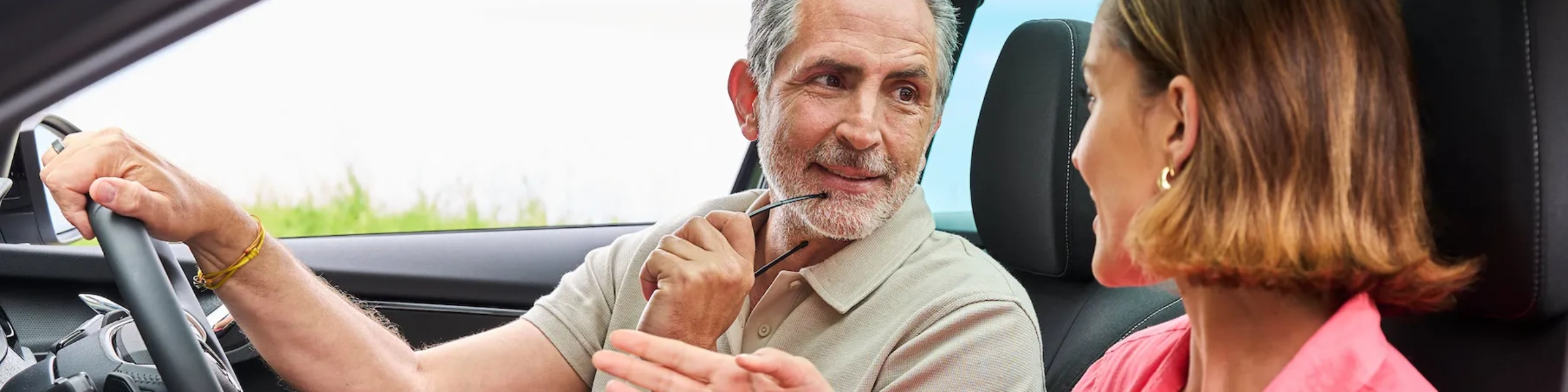 Mann und Frau sitzen im Auto und sprechen – Symbolbild für Leasing-Partnerschaft mit BANK-now