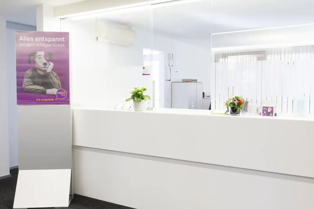 Heller Schalterbereich der BANK-now Filiale Chur mit Empfangstheke und dezenter Wandgestaltung.