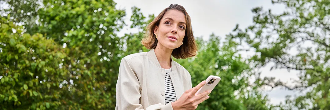 Frau sitzt am Boden im Wohnzimmer und telefoniert