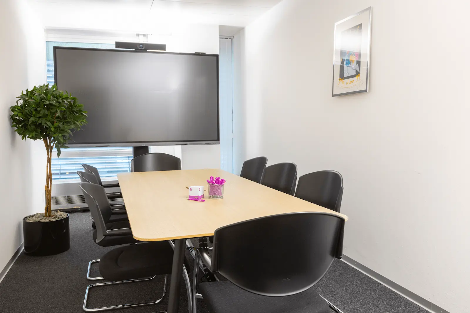 Besprechungsraum der BANK-now Filiale Zürich mit rundem Tisch, Stühlen und grosser Fensterfront.