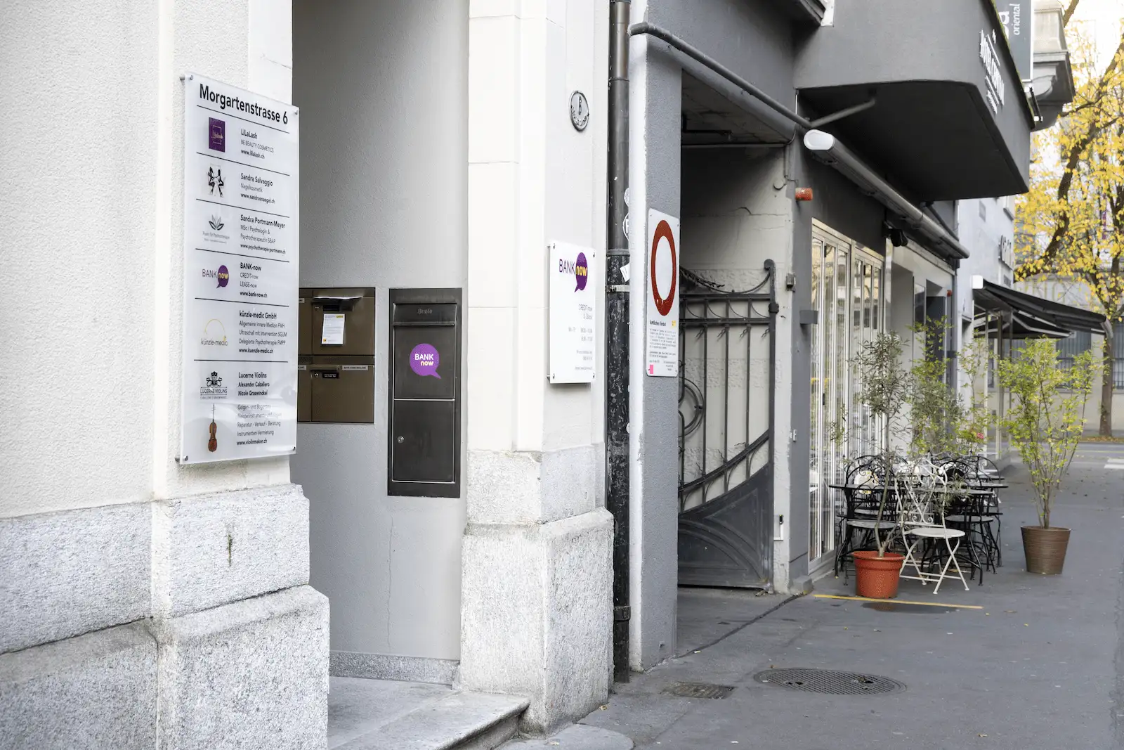 Zweite Aussenansicht der BANK-now Filiale Luzern mit Eingang, Briefkästen und Hinweisschildern.