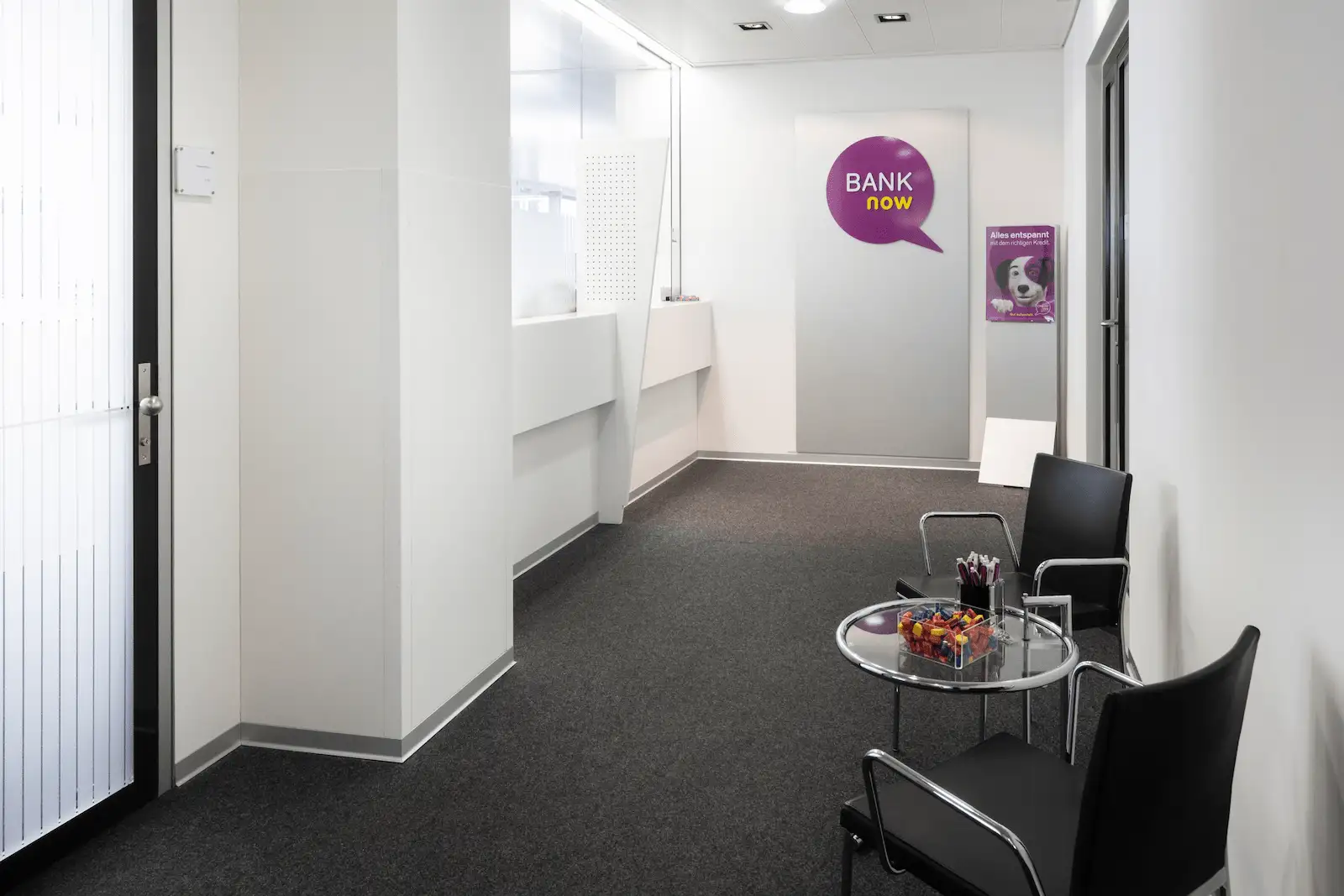 Innerer Eingangsbereich der BANK-now Filiale Zürich-Oerlikon mit Sitzbereich und hellem Innenraum.